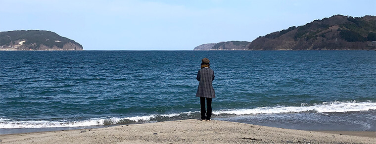 浜辺に立つ女性の画像